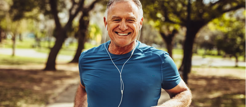 Man smiling while jogging with earphones