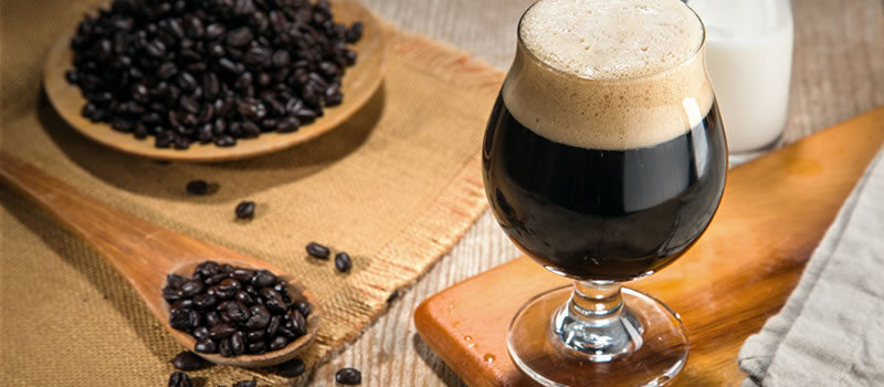 Glass of stout next to plate of coffee beans
